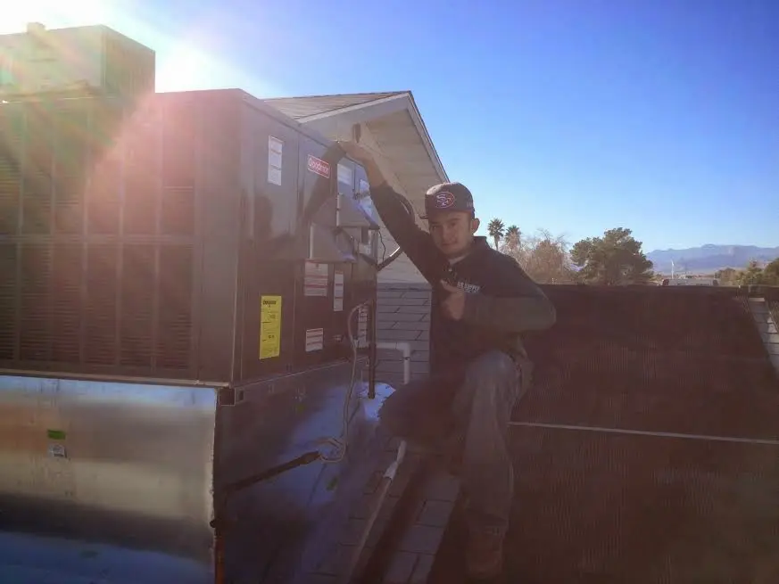 HVAC technician performing Air Duct Repair on a rooftop unit in Daleville